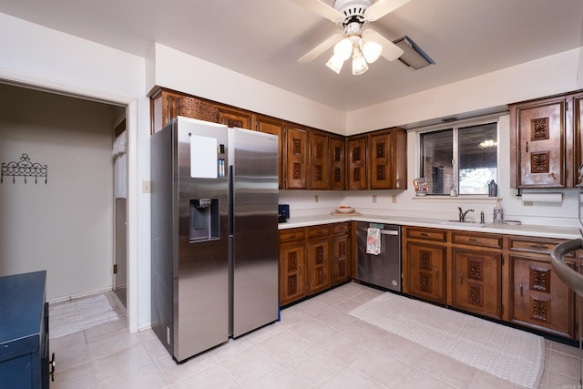 kitchen featuring light tile patterned floors, stainless steel appliances, ceiling fan, and light countertops