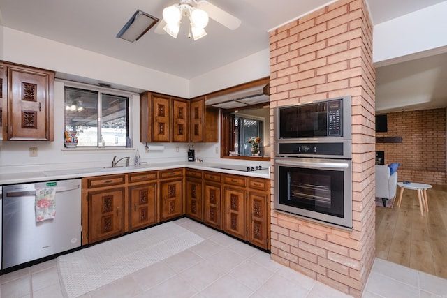 kitchen featuring oven, brown cabinets, built in microwave, light countertops, and dishwashing machine