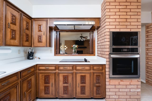 kitchen featuring oven, black electric stovetop, ceiling fan, light countertops, and brown cabinets