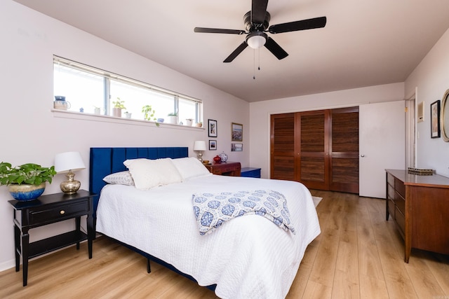 bedroom featuring a closet, light wood-style floors, and a ceiling fan