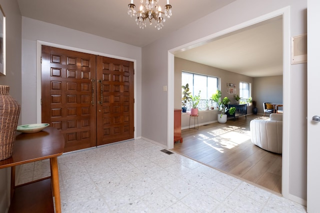 entrance foyer with tile patterned floors, a notable chandelier, visible vents, and baseboards