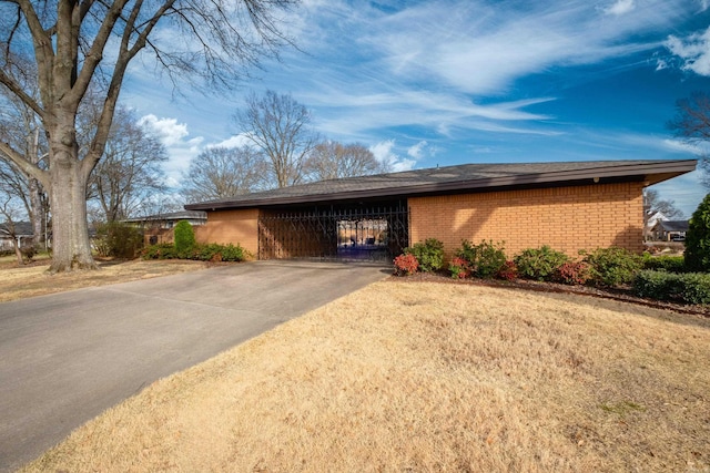 view of front of property featuring brick siding, concrete driveway, and a carport