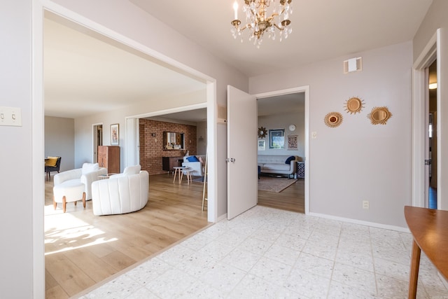 hall with an inviting chandelier, light floors, and baseboards