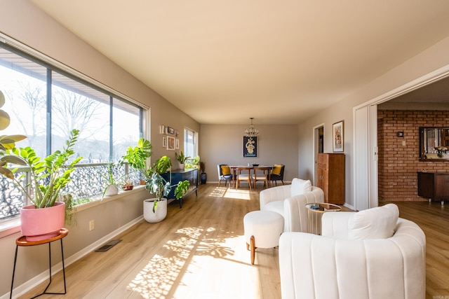 living room featuring visible vents, light wood-style flooring, and baseboards