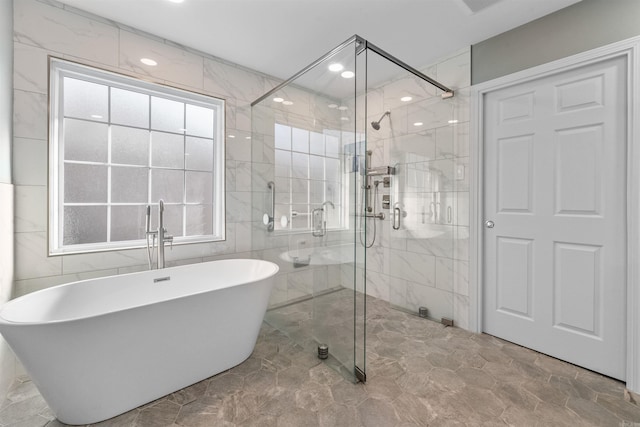 full bath with a stall shower, tile walls, and a freestanding tub