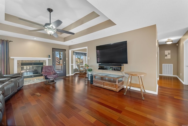 living area featuring visible vents, a raised ceiling, and wood finished floors