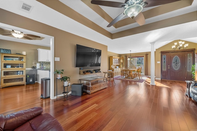 living room with wood finished floors, visible vents, a tray ceiling, decorative columns, and ceiling fan with notable chandelier