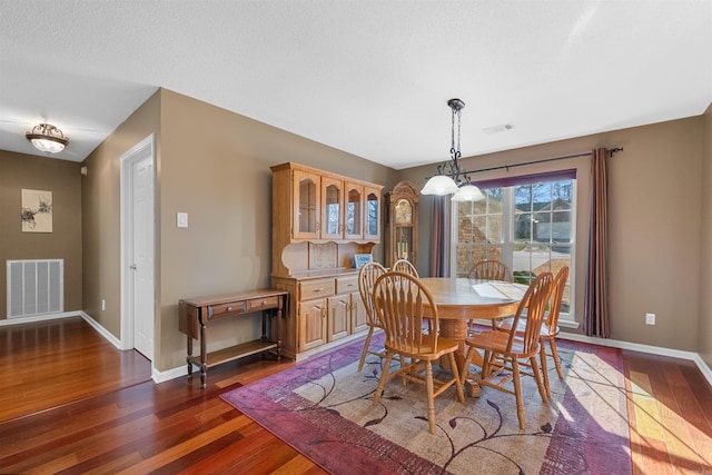 dining area with baseboards, visible vents, and dark wood-style flooring