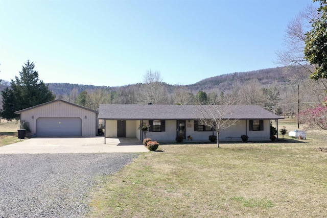 ranch-style house featuring a mountain view, an outdoor structure, a garage, and a front yard