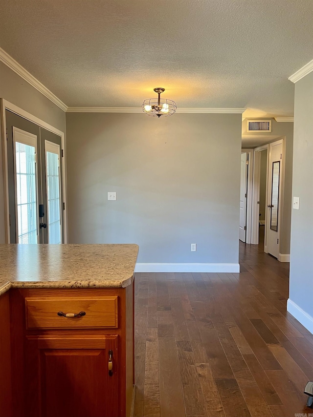 kitchen featuring visible vents, dark wood-type flooring, ornamental molding, and light countertops