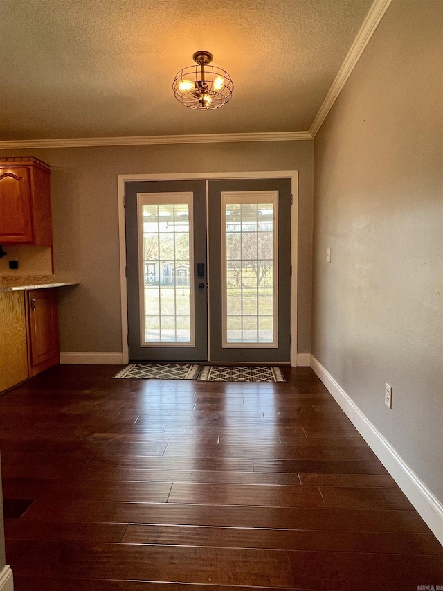 unfurnished dining area with french doors, a textured ceiling, dark wood-style floors, and ornamental molding