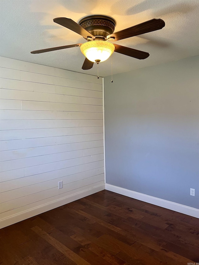 unfurnished room featuring dark wood finished floors, baseboards, and a textured ceiling