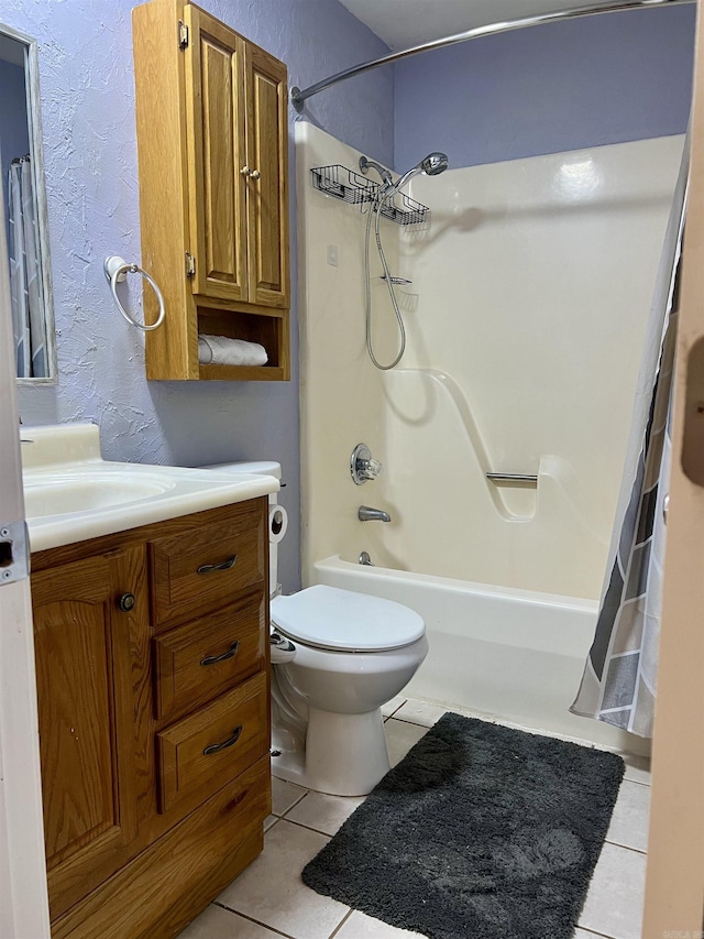 bathroom featuring tile patterned floors, shower / bath combo with shower curtain, toilet, vanity, and a textured wall