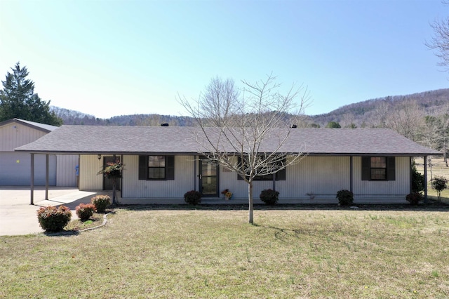 ranch-style home featuring a front lawn and a shingled roof