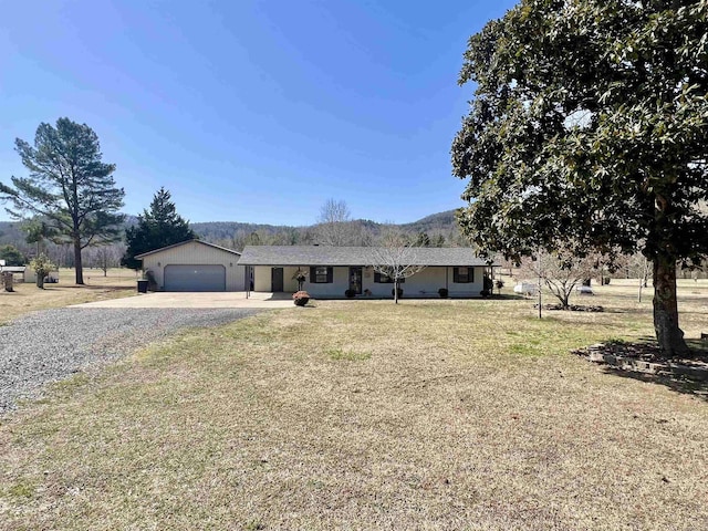 ranch-style house with driveway, an attached garage, and a front yard