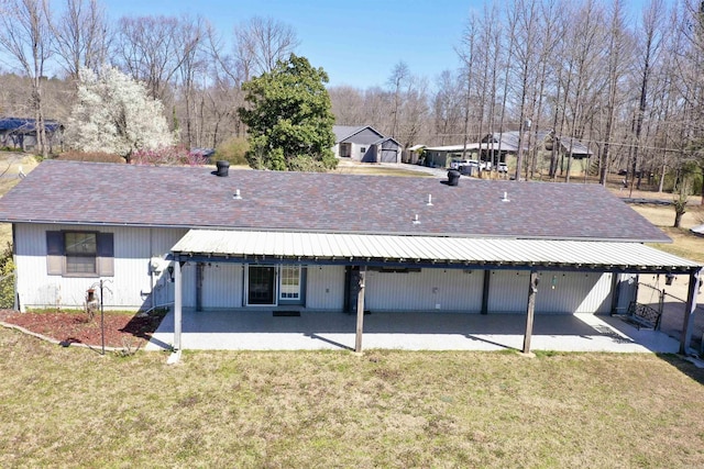 back of property with a yard and a patio