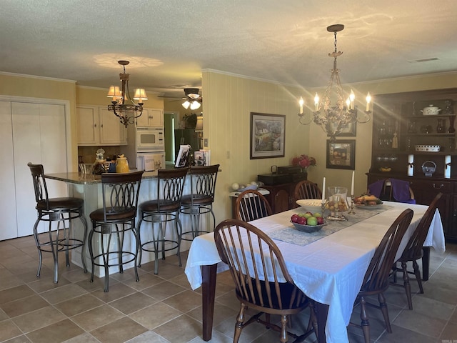 dining room featuring visible vents, ornamental molding, a textured ceiling, dark tile patterned floors, and ceiling fan with notable chandelier