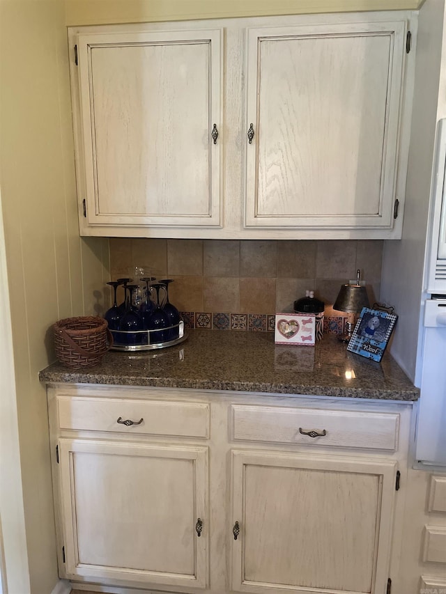 kitchen with tasteful backsplash and dark stone countertops