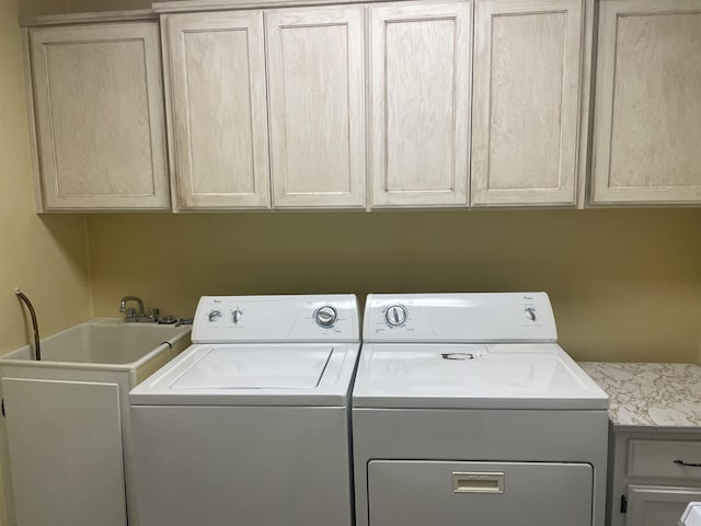 clothes washing area with cabinet space and washing machine and dryer