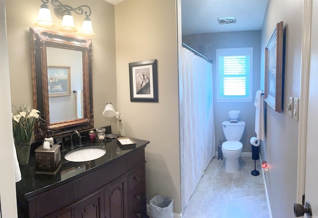 bathroom with vanity, baseboards, visible vents, tile patterned flooring, and toilet