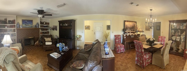 living room with visible vents, ceiling fan with notable chandelier, and a fireplace