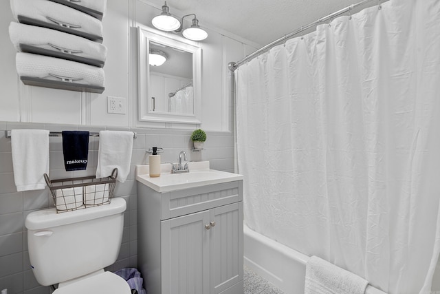 bathroom with tile walls, toilet, shower / tub combo with curtain, wainscoting, and vanity