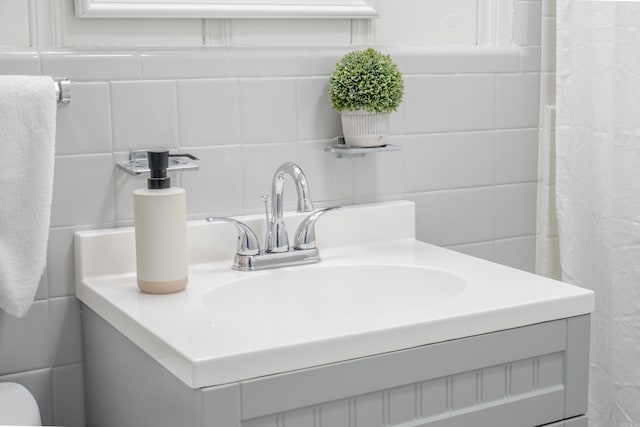 bathroom featuring vanity and tile walls