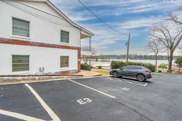 uncovered parking lot featuring a water view