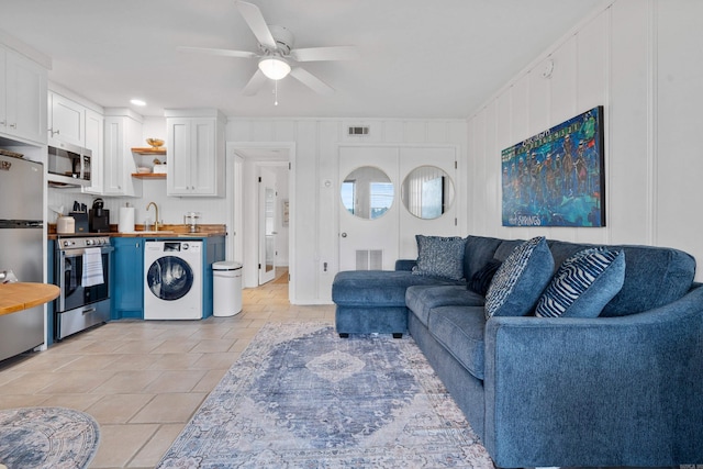 living room with washer / clothes dryer, visible vents, and ceiling fan