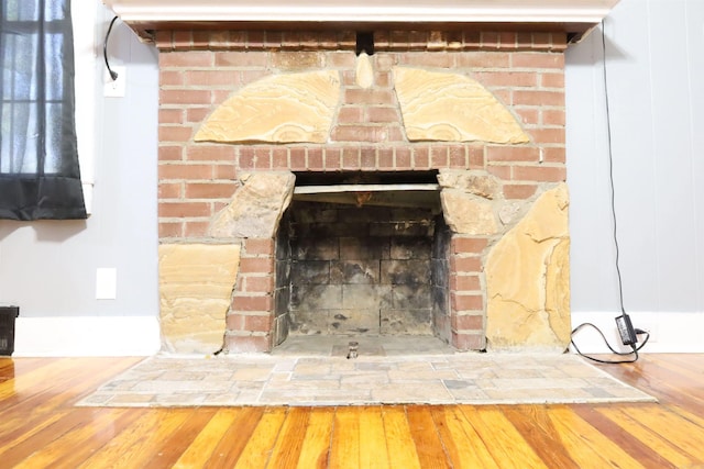 interior details featuring a brick fireplace and wood finished floors