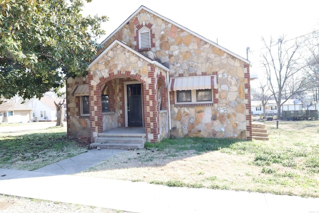 view of front of house with stone siding and a front lawn