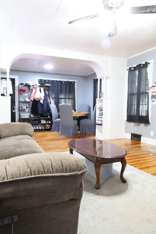 living room featuring arched walkways and wood finished floors