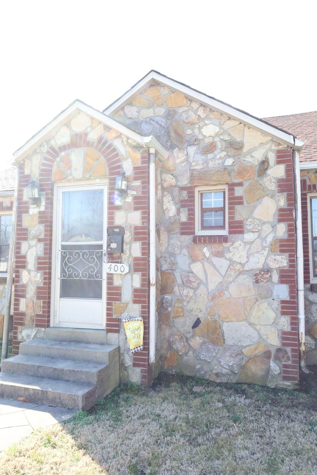 doorway to property featuring stone siding