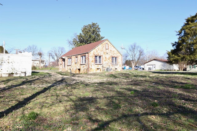 view of front of home featuring stone siding and a front yard