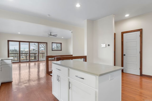 kitchen featuring a ceiling fan, light wood-style flooring, recessed lighting, white cabinets, and a center island