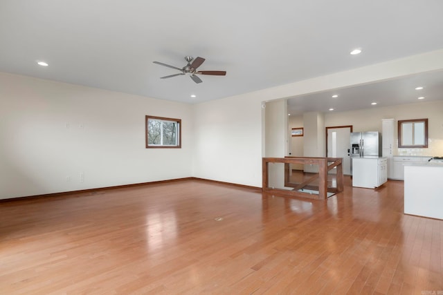 unfurnished living room with recessed lighting, baseboards, a ceiling fan, and light wood finished floors