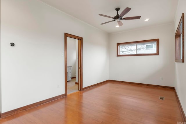 unfurnished room with baseboards, ornamental molding, a ceiling fan, and light wood finished floors