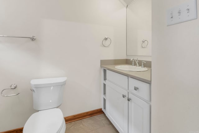 bathroom featuring vanity, toilet, and baseboards