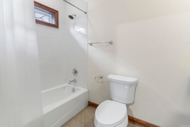 bathroom featuring tile patterned floors, baseboards, toilet, and  shower combination