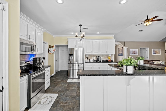 kitchen with visible vents, decorative backsplash, white cabinets, appliances with stainless steel finishes, and stone finish floor