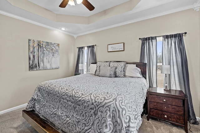 carpeted bedroom featuring ceiling fan, crown molding, a raised ceiling, and baseboards