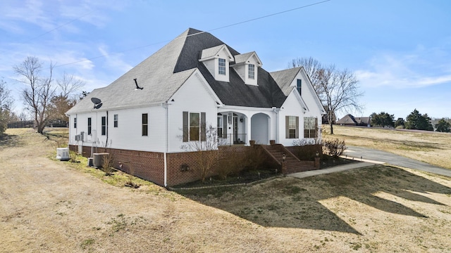 view of front facade with roof with shingles and central AC unit