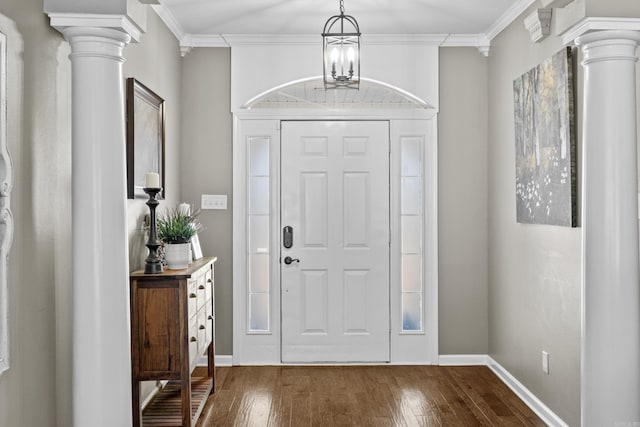 entrance foyer featuring decorative columns, ornamental molding, and dark wood-style flooring