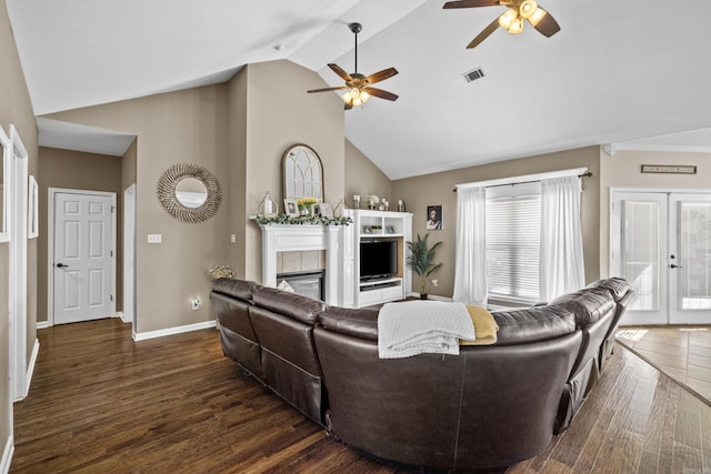 living room with visible vents, a tiled fireplace, wood finished floors, french doors, and baseboards