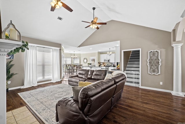 living area with visible vents, stairway, ceiling fan with notable chandelier, wood finished floors, and ornate columns