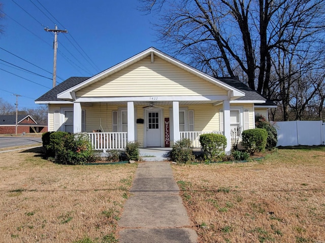 bungalow featuring a porch, fence, and a front yard