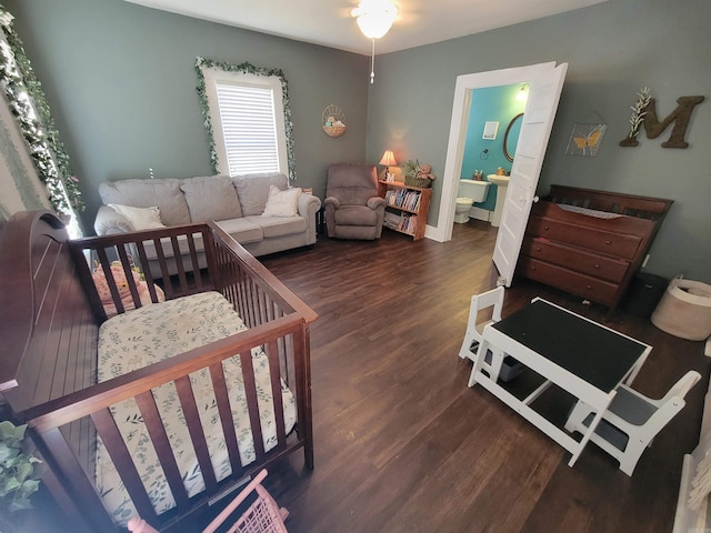 bedroom featuring baseboards, wood finished floors, and ensuite bathroom