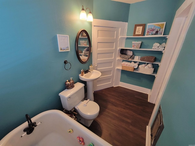 bathroom featuring a freestanding tub, toilet, visible vents, and wood finished floors