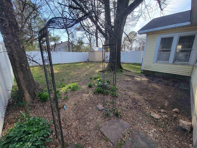 view of yard featuring a fenced backyard, a storage shed, and an outdoor structure