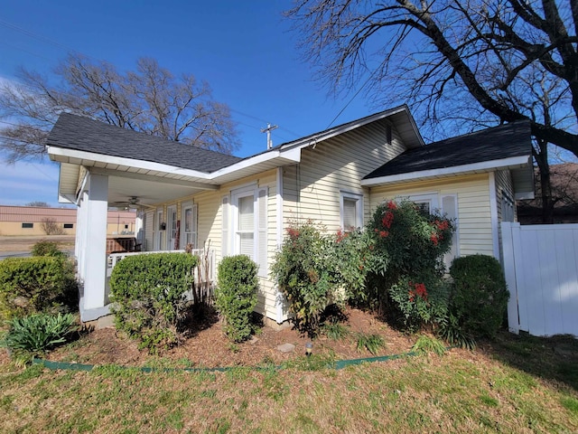 view of property exterior with a porch and fence